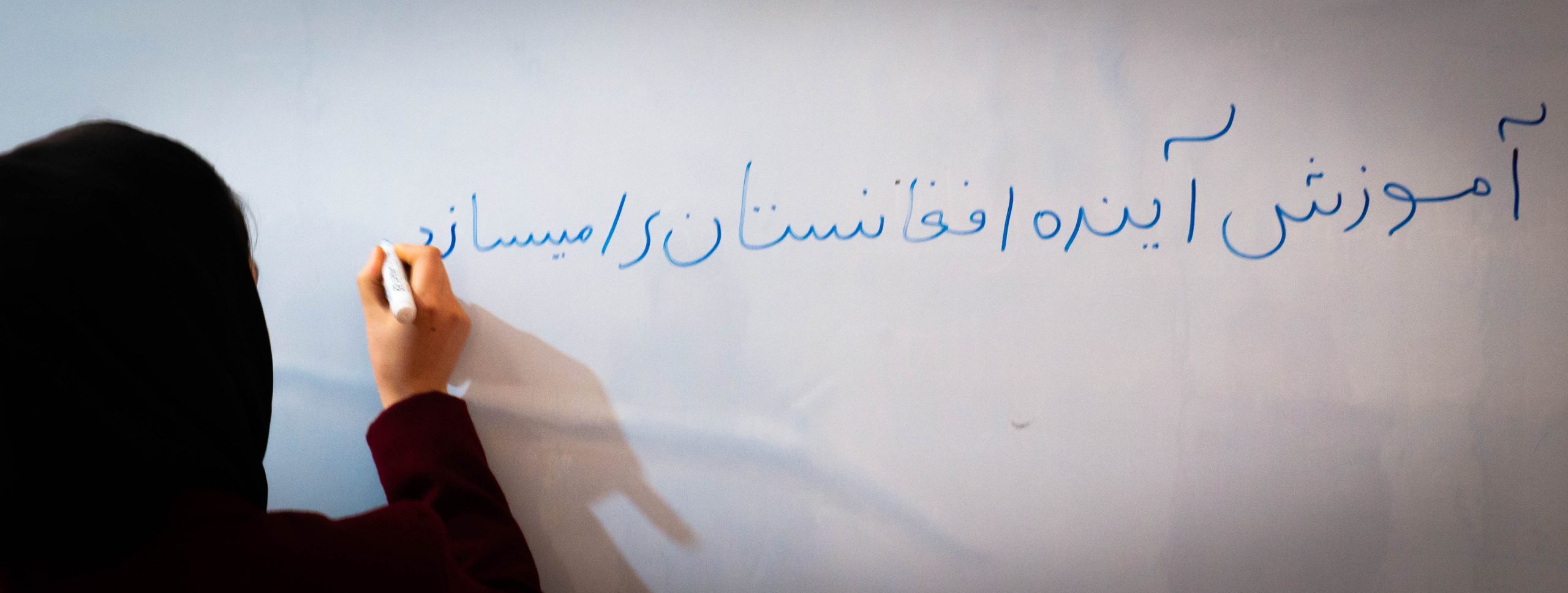 FTEP-trainee writes Education is the future of Afghanistan on the whiteboard